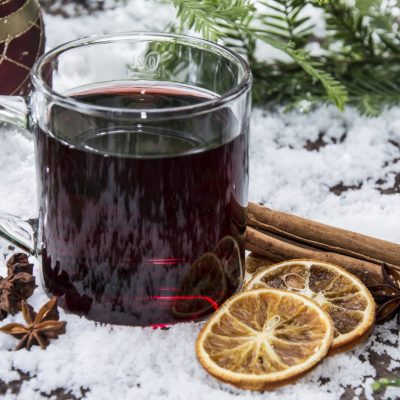 glass with mulled wine in snow background